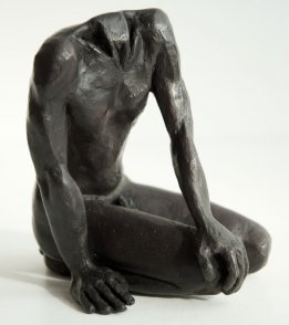 dexter lateral frontal view of a sculpture of a male nude sitting on his knees