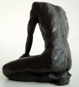 sinister lateral dorsal view of a sculpture of a male nude sitting on his knees