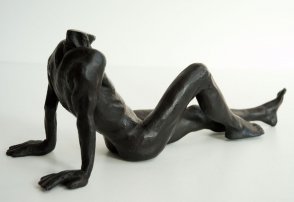 lateral dorsal view of a bronze sculpture of a male nude sitting and leaning back on his arms