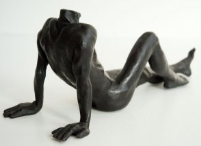 dorsal lateral view of a bronze sculpture of a male nude sitting and leaning back on his arms