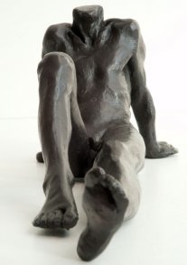 frontal view of a bronze sculpture of a male nude sitting and leaning back on his arms