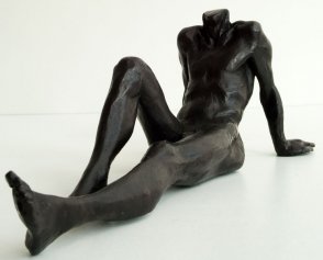 frontal lateral view of a bronze sculpture of a male nude sitting and leaning back on his arms