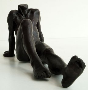 frontal lateral view of a bronze sculpture of a male nude sitting and leaning back on his arms