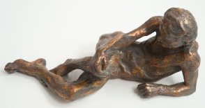 frontal view of bronze sculpture of a male nude leaning on his ellbow