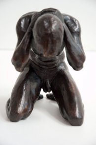 frontal view of a bronze sculpture of a male nude kneeling down