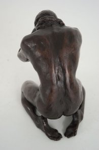 cranial dorsal view of a bronze sculpture of a male nude kneeling down