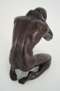 cranial dorsal lateral view of a bronze sculpture of a male nude kneeling down