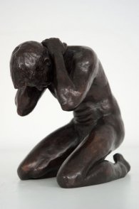 lateral frontal view of bronze sculpture of a male nude kneeling down