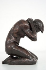 lateral view of a bronze sculpture of a male nude kneeling down