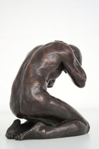 lateral dorsal view of a bronze sculpture of a male nude kneeling down