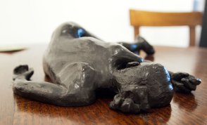 Bronze sculpture of a female nude lying on a table