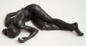 cranial frontal view of bronze sculpture of a female nude lying down