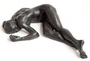frontal view of bronze sculpture of a female nude lying down