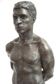 frontal lateral view of bust of bronze sculpture of male nude standing figure