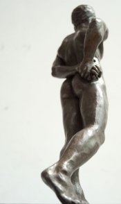 caudal dorsal lateral view of bronze sculpture of standing male nude figure
