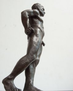 caudal lateral view of bronze sculpture of standing male nude figure