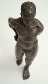 cranial frontal view of bronze sculpture of male nude standing figure