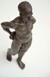 cranial frontal lateral view of bronze sculpture of male nude standing figure