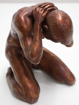 a bronze sculpture of a male nude model sitting on his knees with his hands in his neck, bending a little over