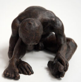 bronze sculpture of a male nude sitting with his head resting on his knee