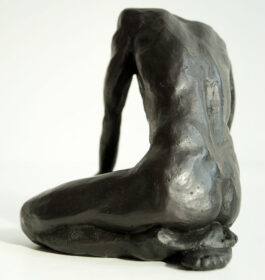 bronze sculpture of a male nude sitting on his knees
