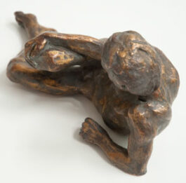 Bronze sculpture of male nude reclining and resting on his ellbow