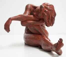 Bronze sculpture of a female nude sitting with one leg streched